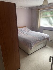 House Clearance Birmingham4 Garden Clearance A bedroom with a double bed, wardrobe, and a window with blinds, showing the type of bedroom furniture and contents removed during a property clearance.