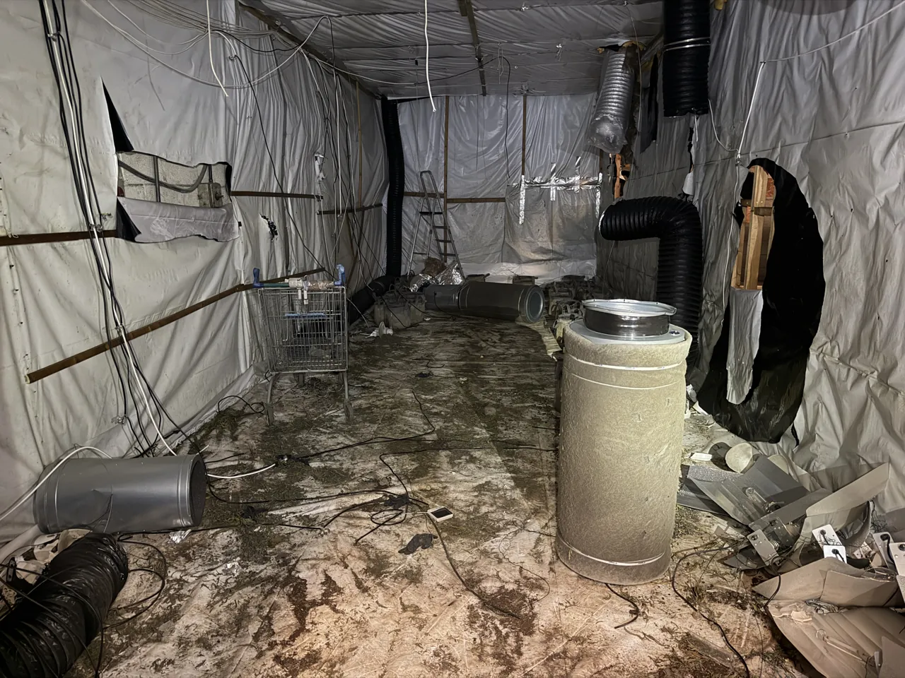 Cannabis farm grow room in Coventry lined with reflective sheeting, with ducting, a carbon filter and cabling