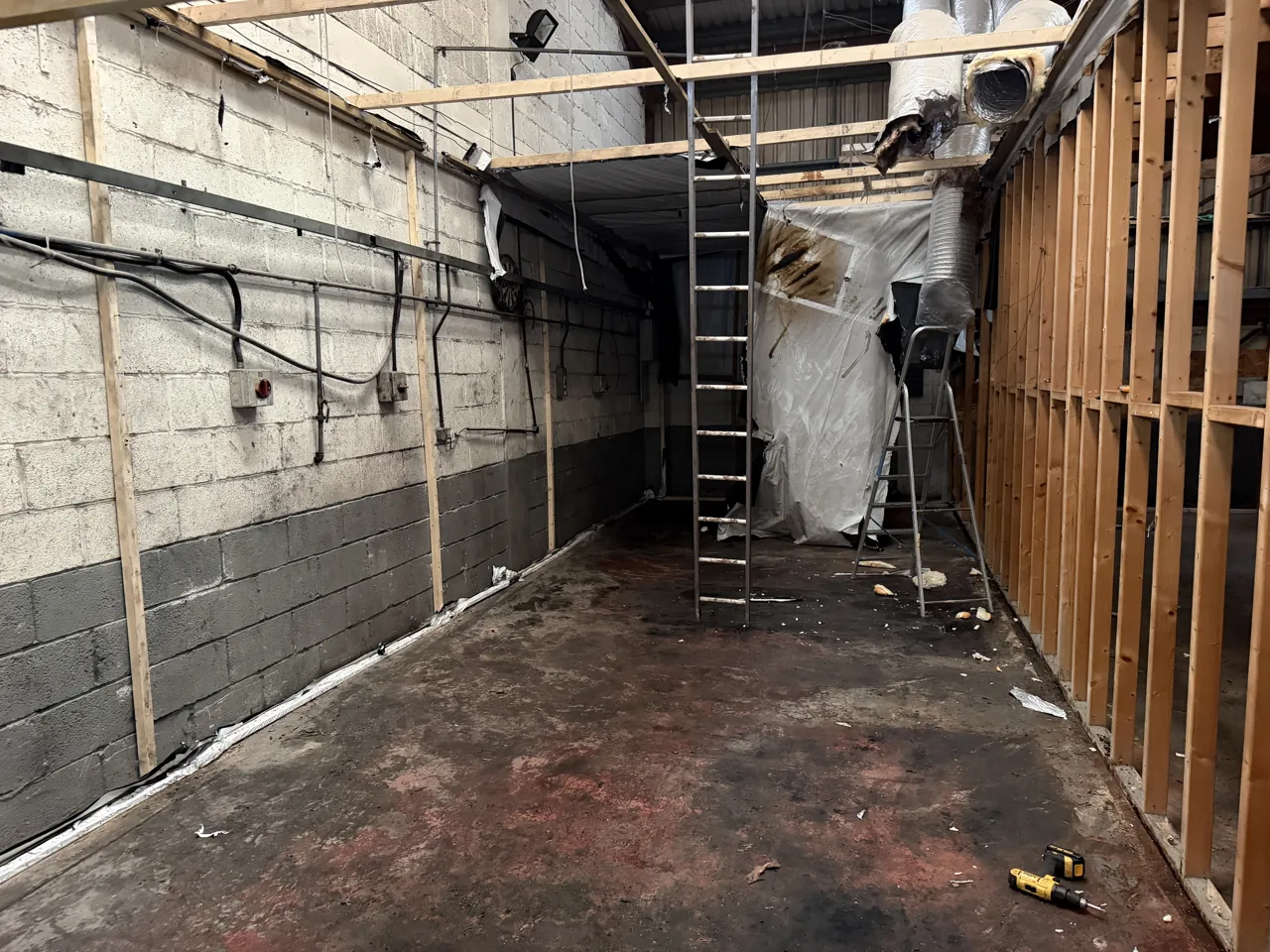 Industrial unit in Coventry with a cannabis farm stripped back to its timber frame, ladders still in place