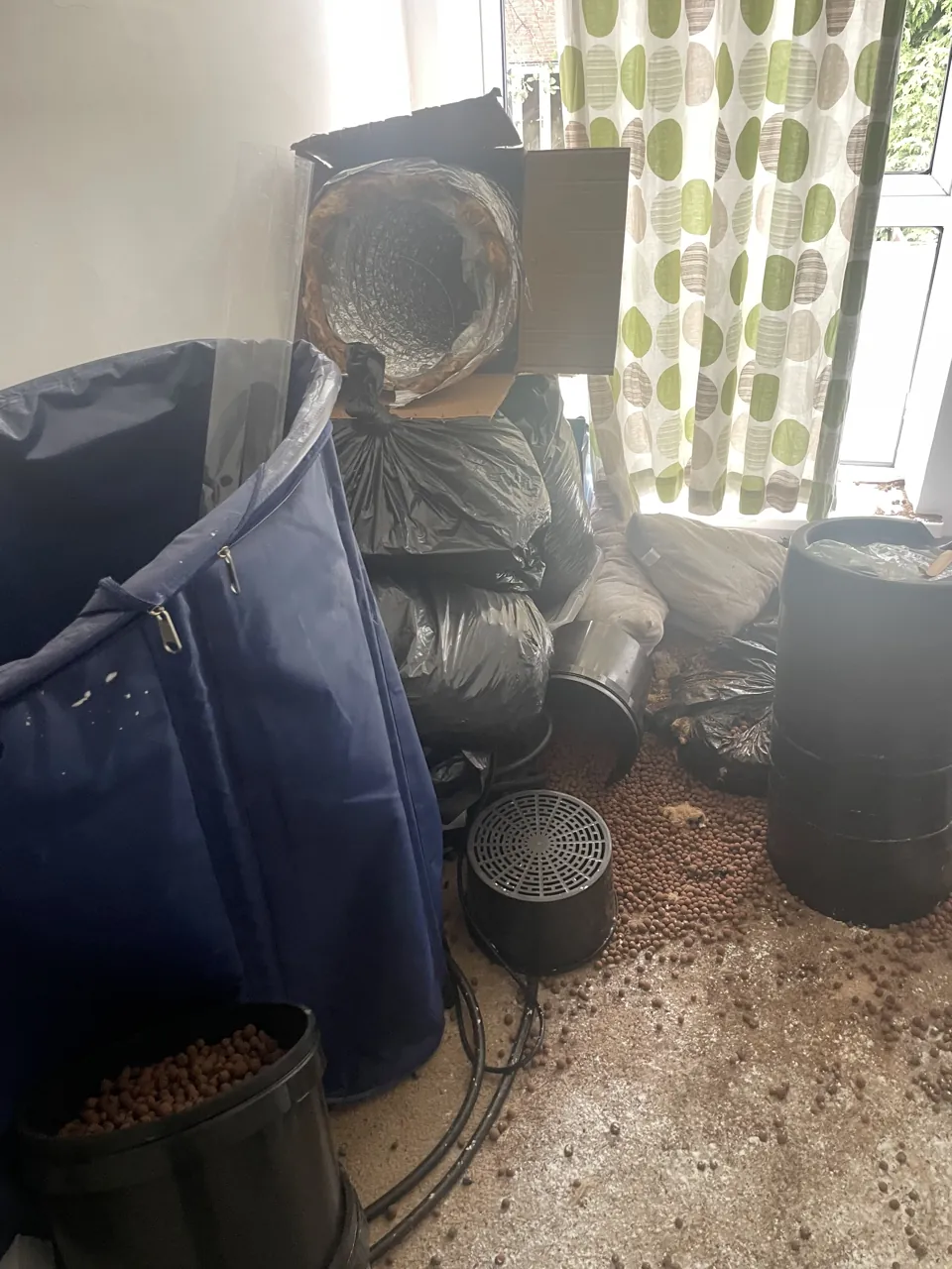 Hydroponic pots, clay pebbles and ducting left in a room used as a cannabis grow