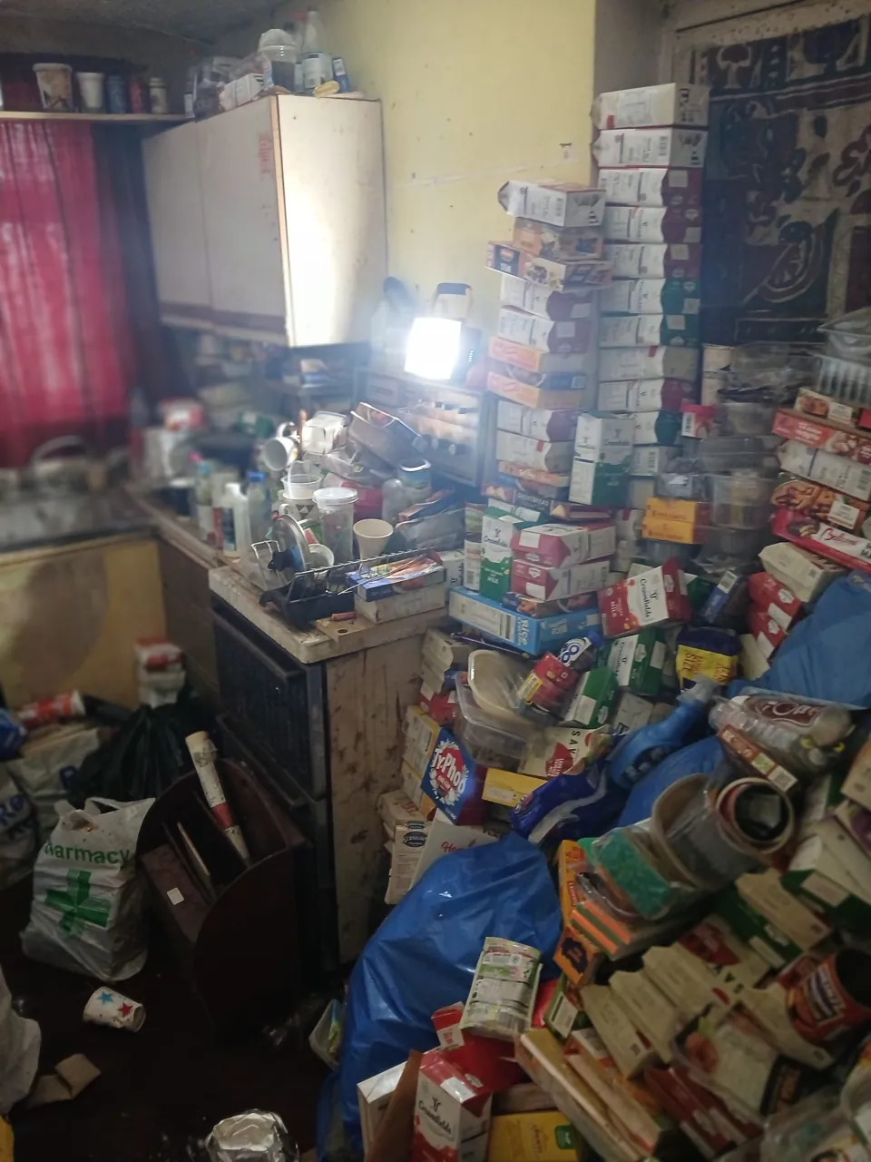 DrClear team clearing a flat kitchen in Walsall, West Midlands, stacked high with boxes and bags